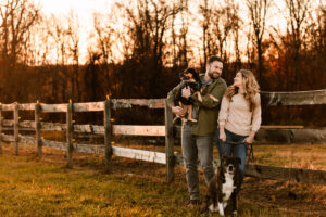 smiling couple with their dogs on a farm ct professional pet photography